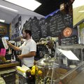 Brandon Karn, owner of Jammin Java on the Fayetteville square, rings up an order Wednesday. The coff...