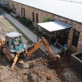 Workers with SPI of Springdale dig around the entrance to Old High Middle School on Friday in Benton...