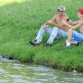 Jimmy Nelson, left, and Tyler Wade, 13, fish from a shady spot Monday alongside Lake Bentonville in ...