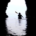 Kayak guide Rod Feldtmann paddles back into the light after exploring a cave on the north coast of M...
