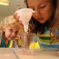 Abby Lawson, 6, winces as Savannah Pledger, 7, pours water through a filter while the two were takin...