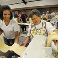 Kara Jo McKinley, left, and Jettie Franco roll pasta before it is cut into spaghetti and hung to dry...