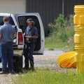 Workers with Waste Services of Little Rock prepare to secure leaking chemicals Thursday at the forme...