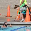 After competing in his own age division, Daniel Hines, 10, hands his father, Joe Hines, his glasses ...