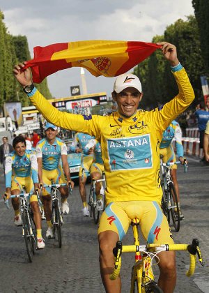  Three-time Tour de France winner Alberto Contador of Spain holds aloft the Spanish national flag during a victory lap with his Astana teammates after the 20th and last stage of the Tour de France cycling race over 102.5 kilometers (63.7 miles) with start in Longjumeau and finish in Paris, France, Sunday, July 25, 2010.  