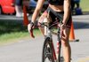 Maggie Pickhardt pedals her way to her third victory in women’s sprint division of the Shark Fest IV Triathlon at Horseshoe Bend Park on Sunday at Beaver Lake.