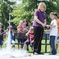 Warren Cox, middle, helps Ethan Buck, right, 11, launch his homemade rocket Tuesday during Mad Scien...