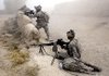 U.S. soldiers stand guard Friday as a medical helicopter arrives to evacuate an injured soldier near Kandahar, Afghanistan.