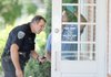 FILE — Sgt. Shannon Gabbard, left, and John Brooks, crime scene investigator, work on July 29, 2010 to collect fingerprints from the front door of First Federal Bank at 3460 N. College Ave. after it was robbed in Fayetteville. Police have linked the robber to nearly a dozen other bank robberies in Louisana, Oklahoma and New Mexico.