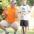 BREAKING LEFT - Jason Tyer of Bella Vista helps his 6-year-old son, Braden, line up his putt Saturda...