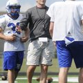 Rogers High football coach Shawn Flannigan speaks to quarterback Nick Wary, right, at spring practic...
