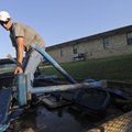 Josh Downing, a Fayetteville School District employee, loads a bench onto a truck Monday at the Bate...