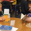 Hayden Thompson, 6, and Leah White, 7, gather the books they are checking out from the library Monda...