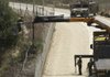 Israeli soldiers use a crane as they cut a tree near the village of Adaisseh, Lebanon, along the border of Israel and Lebanon. Both Israel and Lebanon claimed that the tree was in their territory.