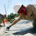 Brian Pharis (right) and Jacob Ralston with Necessary Construction of Rogers smooth concrete Tuesday...