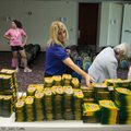 Susan Miller, center, fills a backpack with school supplies Wednesday at the Jones Center in Springd...