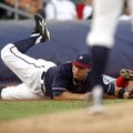 Northwest Arkansas third baseman Jamie Romak stretches but is unable to field a throw from catcher M...