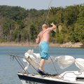 Jeff Doss of Fayetteville heaves an anchor from the bow of his 22-foot sailboat near the Arkansas 12...