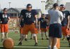 Rogers Heritage offensive lineman Bill Couch, center, listens to a coach before starting a drill during practice Monday morning in Rogers.