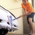 Bentonville High School student Blake Red scrubs his 1994 Ford Mustang at the Splash-N-Dash car wash...