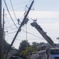 Crews from Southwest Electric Power work Tuesday at righting a power pole that was pulled down when ...