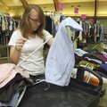 GIVING BACK - Rebekah Egle, 16, organizes clothes Thursday at the First Baptist Church in Bentonvill...