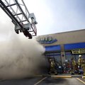 TWO-ALARM FIRE - Rogers firefighters enter the front door of Deals while battling a fire Thursday th...