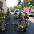 Rogers firefighters take a break in the shade Thursday while battling a fire at Deals in the 100-deg...