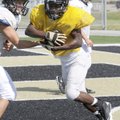  Bentonville High School junior DeMarcus Murphy takes a handoff during practice at Tiger Stadium in ...