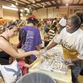 BACK TO SCHOOL BASH - Volunteer Onita Jenkins, right, hands out food Saturday to those in attendance...