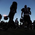 Fayetteville football players head to their position coaches under the lights as the sun sets during...