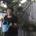 Gail Pianalto stands by one of the many gates decorating her garden at her home in Tontitown. “Where...