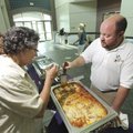 Adam Simmons, director of food services for Fayetteville Public Schools, right, works with food serv...