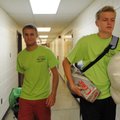 Volunteers Chris Bayles, right, and Tyler Thompson help a student move in to Pomfret Hall at the Uni...