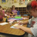 Brooklyn Floyd, 5, left, watches Olivia Smith, 5, color a picture Friday during Adventure Club at R....