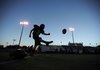 Fayetteville kicker Max Coffin follows through with a kickoff while practicing under the lights as the sun sets during practice Tuesday, Aug. 10, 2010, at Harmon Field.