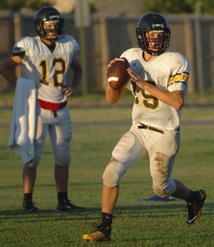 Prairie Grove sophomore quarterback Cooper Winters rolls out during the Tigers’ practice Tuesday morning, while junior quarterback Dakota Daniels looks on. The two are battling for the starting position for Prairie Grove.