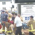 Fayetteville firefighters and paramedics carry a man to a waiting ambulance Tuesday at the corner of...