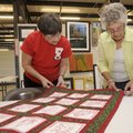 Phyliss Pokorny, left, and Shirley Nielsen judge a Christmas wall hanging Tuesday at the Benton Coun...