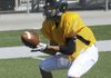Bentonville linebacker Chris Scroggins catches a low pass Monday during practice in Tiger Stadium in Bentonville.