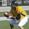 Bentonville linebacker Chris Scroggins catches a low pass Monday during practice in Tiger Stadium in...