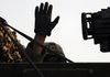 A soldier with the Army’s 4th Stryker Brigade, 2nd Infantry Division, waves Wednesday after his Stryker armored vehicle crosses into Kuwait from Iraq.