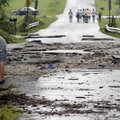 Preston Lane, 12, looks down into a creek after a flash flood tore apart the road behind him on Wedn...