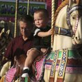 AROUND AND AROUND - Dustin Price, 20 months, of Bentonville, rides the carousel Friday at the Benton...