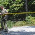 Rhys Gaesswitz, a Washington County sheriff’s deputy, places barrier tape across the driveway at 304...