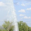 LIKE A GEYSER | A battalion truck from the Fayetteville Fire Department passes by a large plume of w...