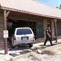 BUILDING CRASH - Sgt. Shannon Gabbard of the Fayetteville Police Department walks away from a Toyota...