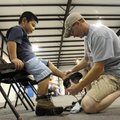 THE RIGHT FIT - Mike McDaniel, right, checks the fit on a pair of hiking boots for Marcus Tobar, 5, ...