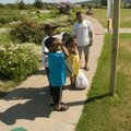 Gabriel Nicolas, right, reads one of the learning station signs along with his children and a niece ...