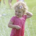 Keira Morrissey, 2, plays in a sprinkler Wednesday during a Little Sprouts education program at Bota...